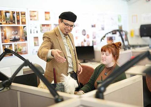 A faculty member shows an interior design student a technique.